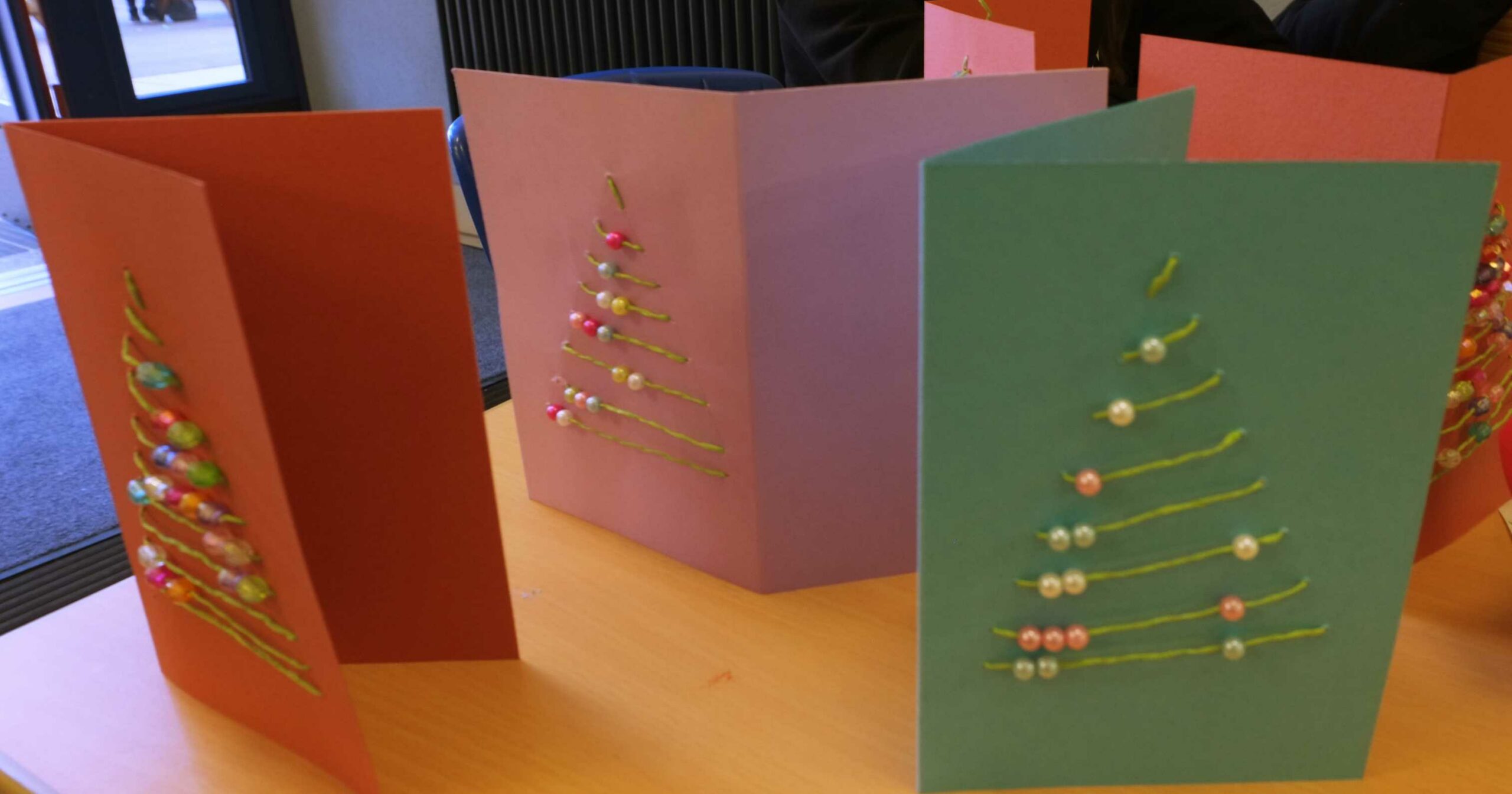 Auf diesem bild sehen Sie gebastelte Weihnachtskarten mit einem Tannenbaum.