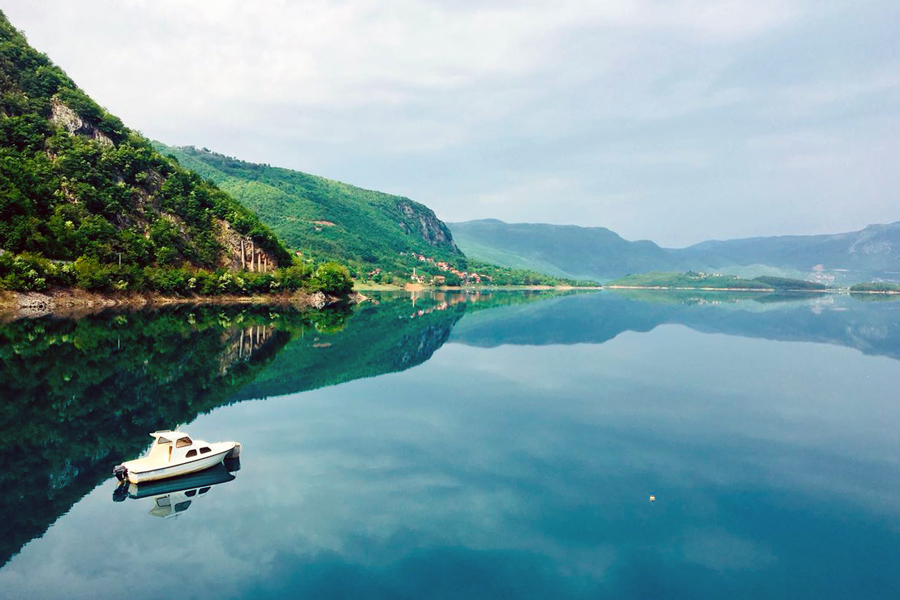 Auf diesem Foto sehen Sie ein kleines Boot auf einem See in Bosnien Herzegowina.