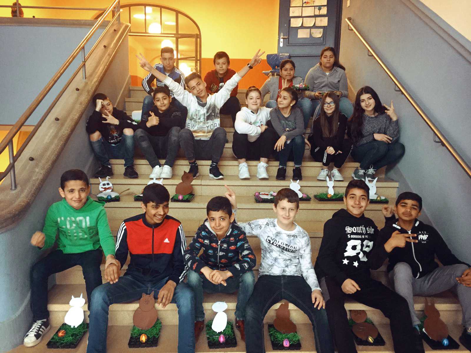 Auf diesem Bild sehen SieSchülerinnen und Schüler, die auf einer Treppe sitzen.