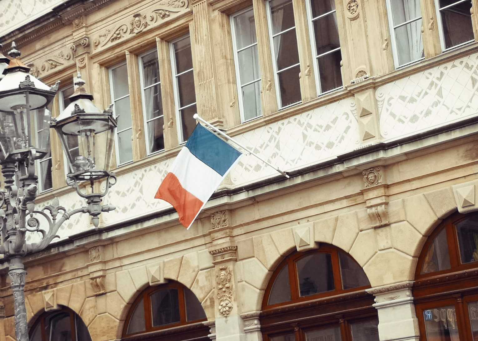 Auf diesem Bild sehen Sie eine französische Flagge aus einem Fenster hängen.