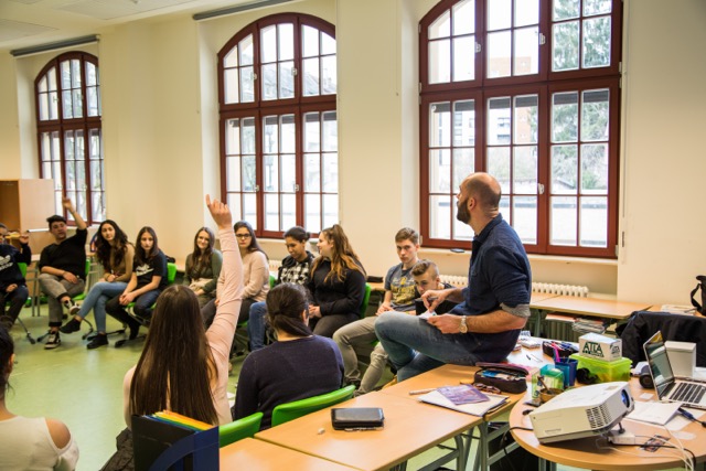 Auf diesem Bild sehen Sie Clemens Beisel, bei einem Vortrag in einem Klassenzimmer.