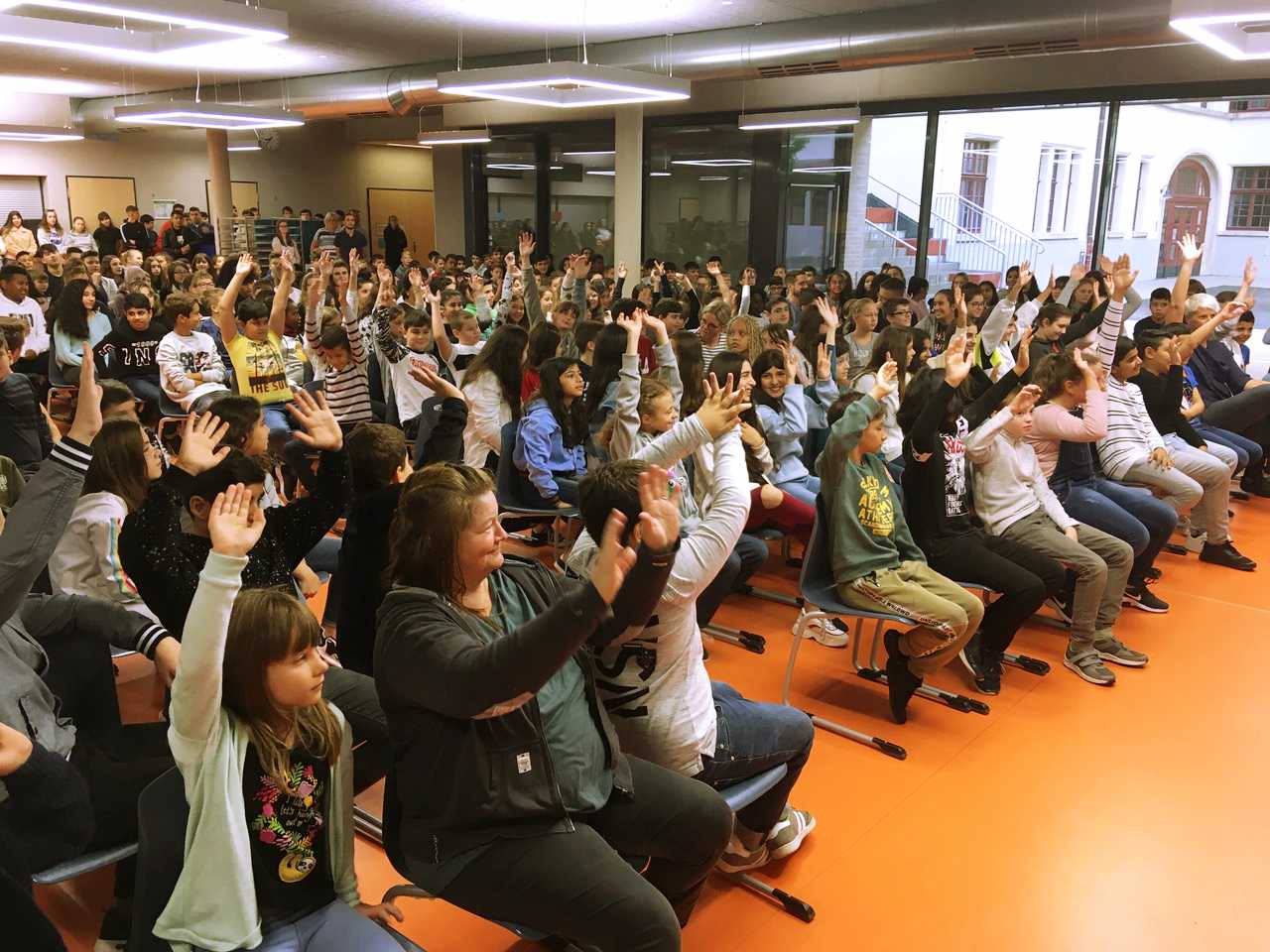 Auf diesem Bild sehen Sie sich meldende Schülerinnen und Schüler in einer SMV Sitzung in der Aula.