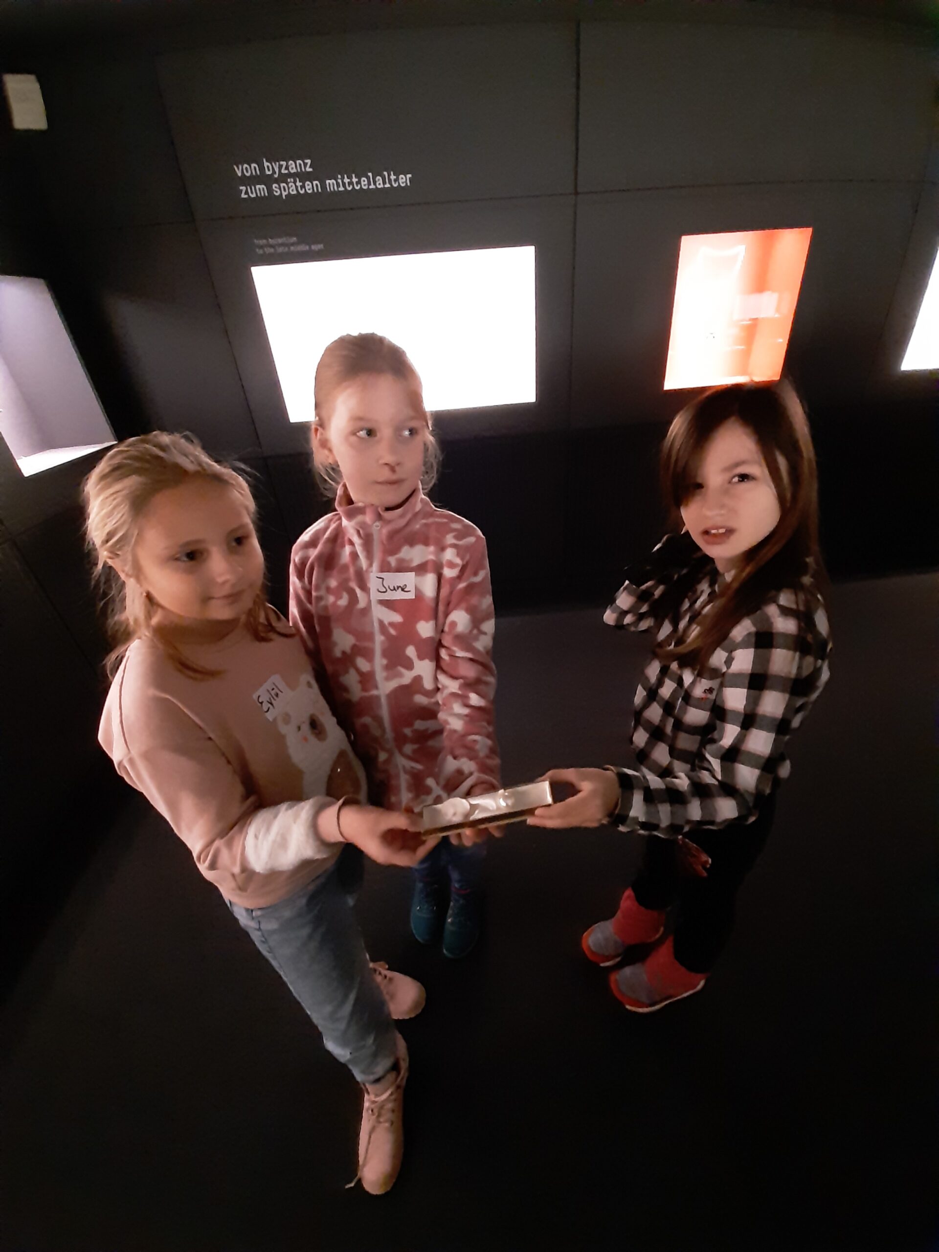 3 Schülerinnen zeigen eine Schachtel mit ihrer Aufgabe
