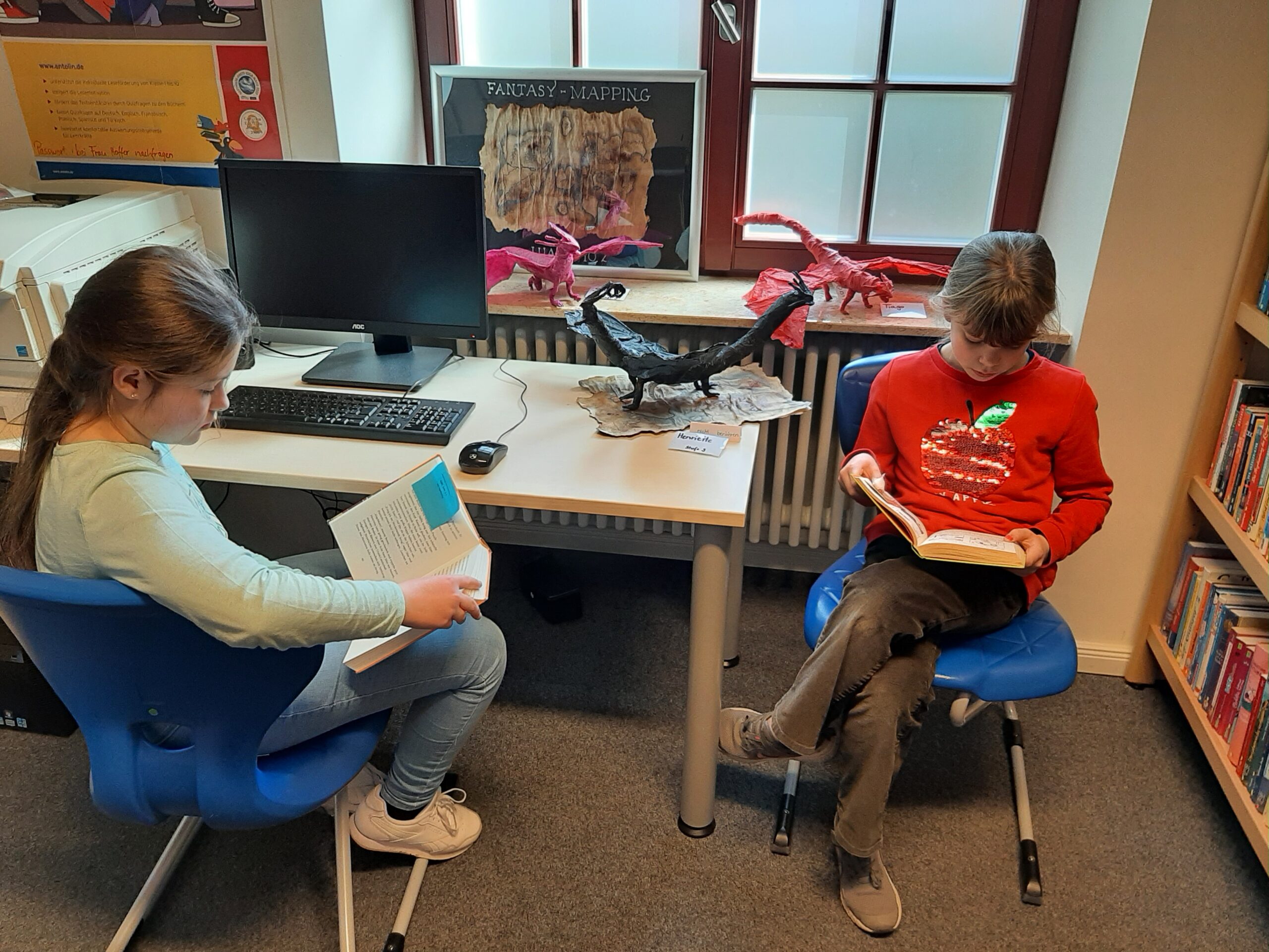 Zwei Schülerinnen lesen in in der Schulbibliothek