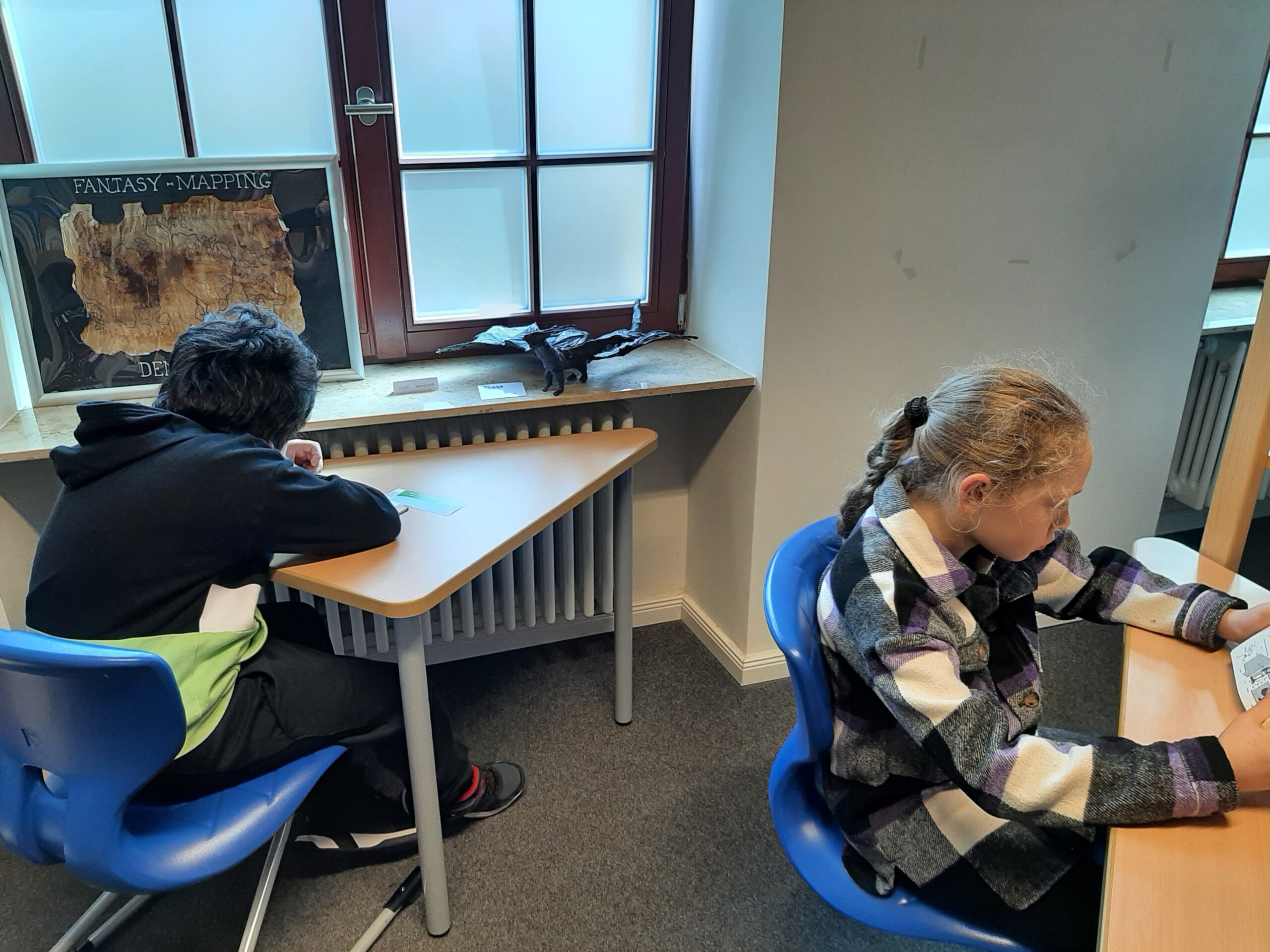 Zwei SchülerInnen lesen in in der Schulbibliothek