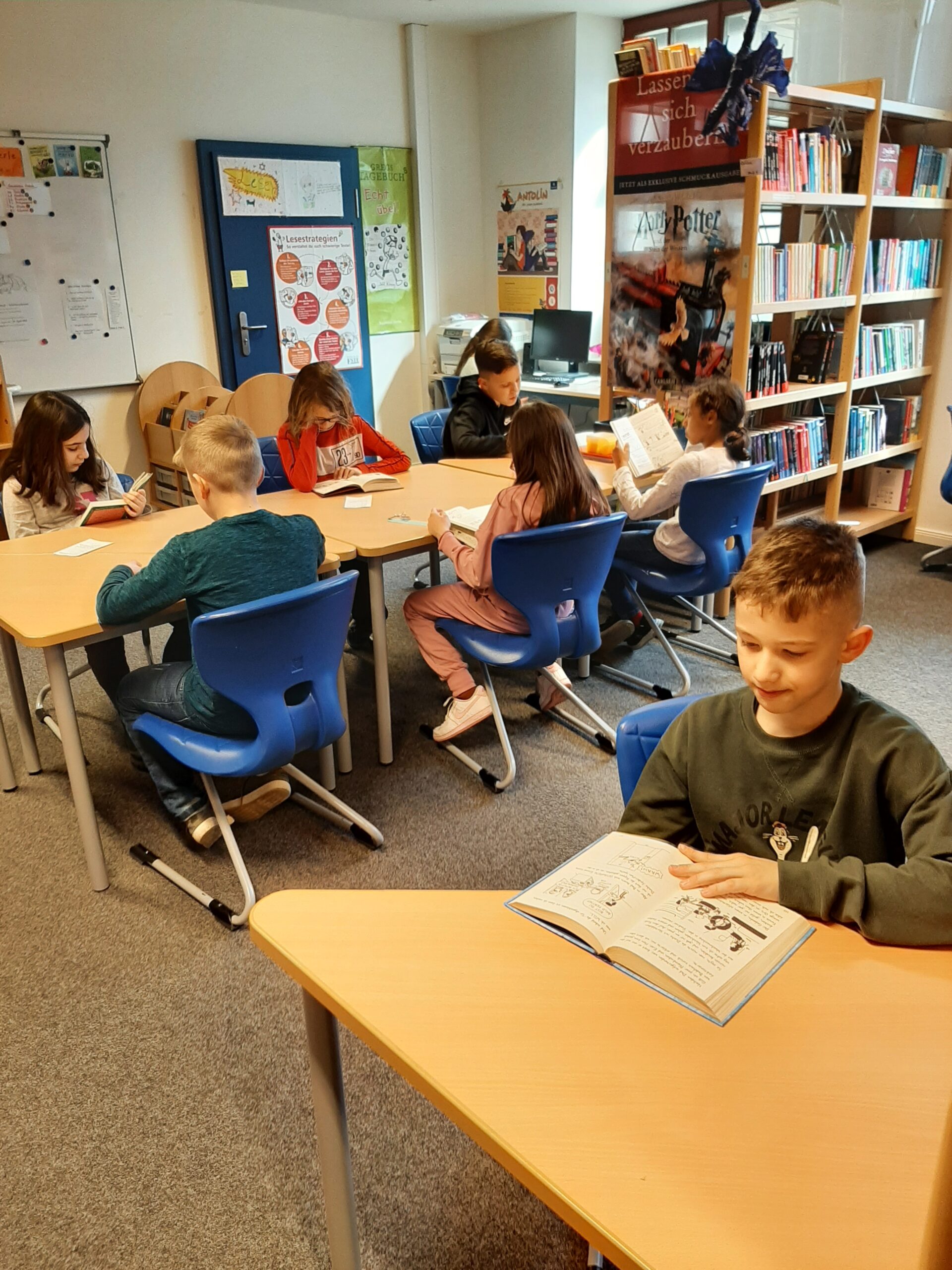 Mehrere Schüler lesen in in der Schulbibliothek