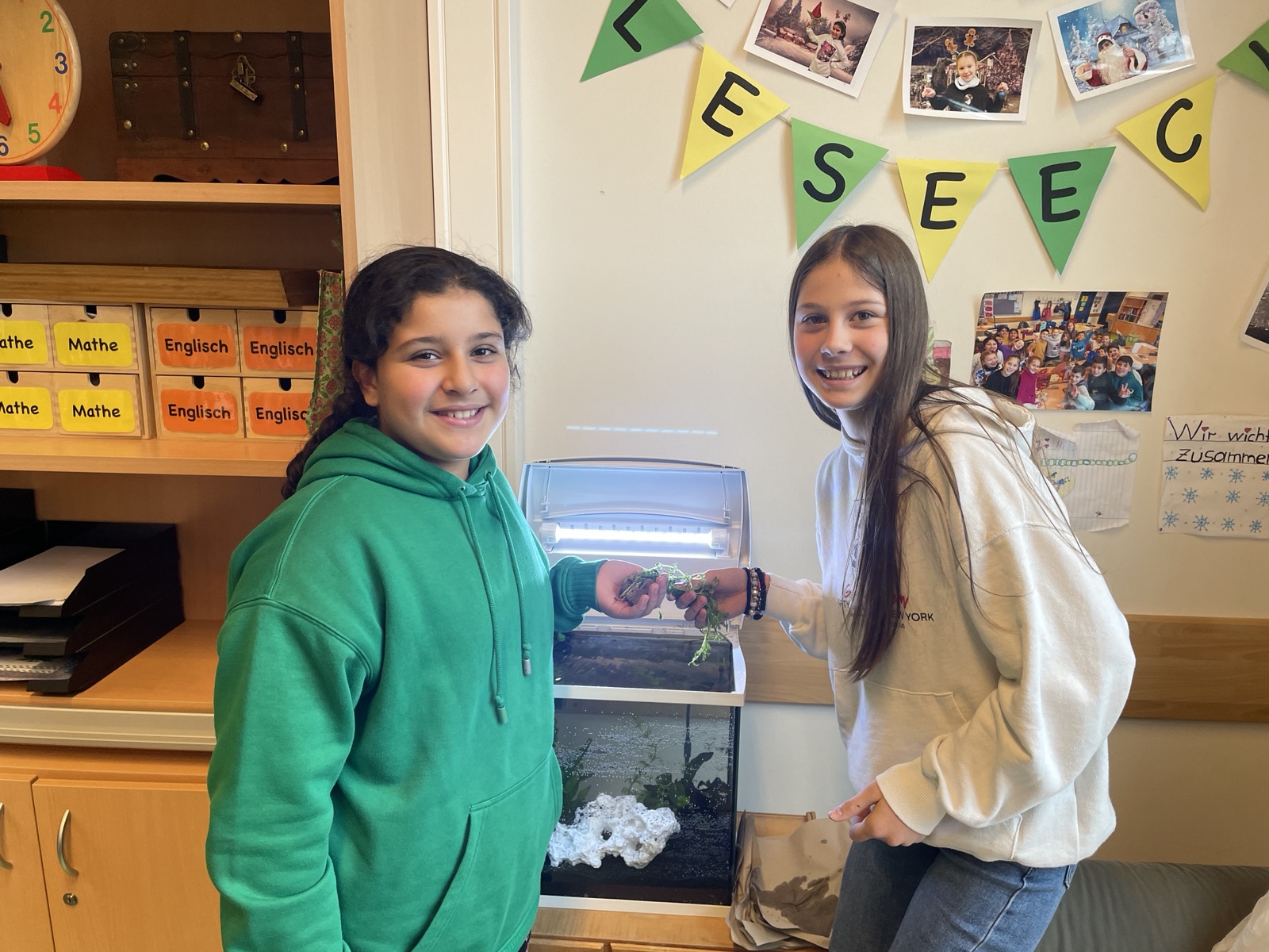 Zwei Schülerinnen bereiten Pflanzen für das neue Aquarium vor