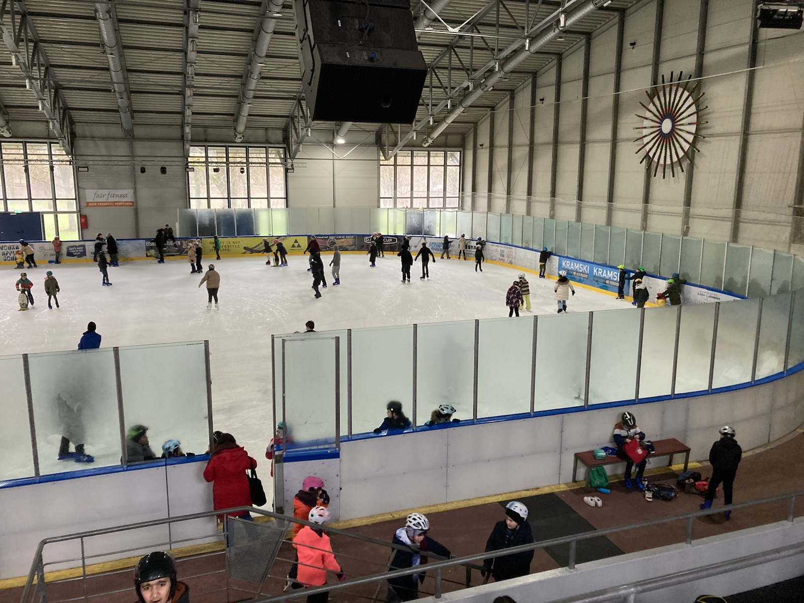 Man sieht Schüler in der Eislaufhalle auf dem Eis Schlittschuh laufen