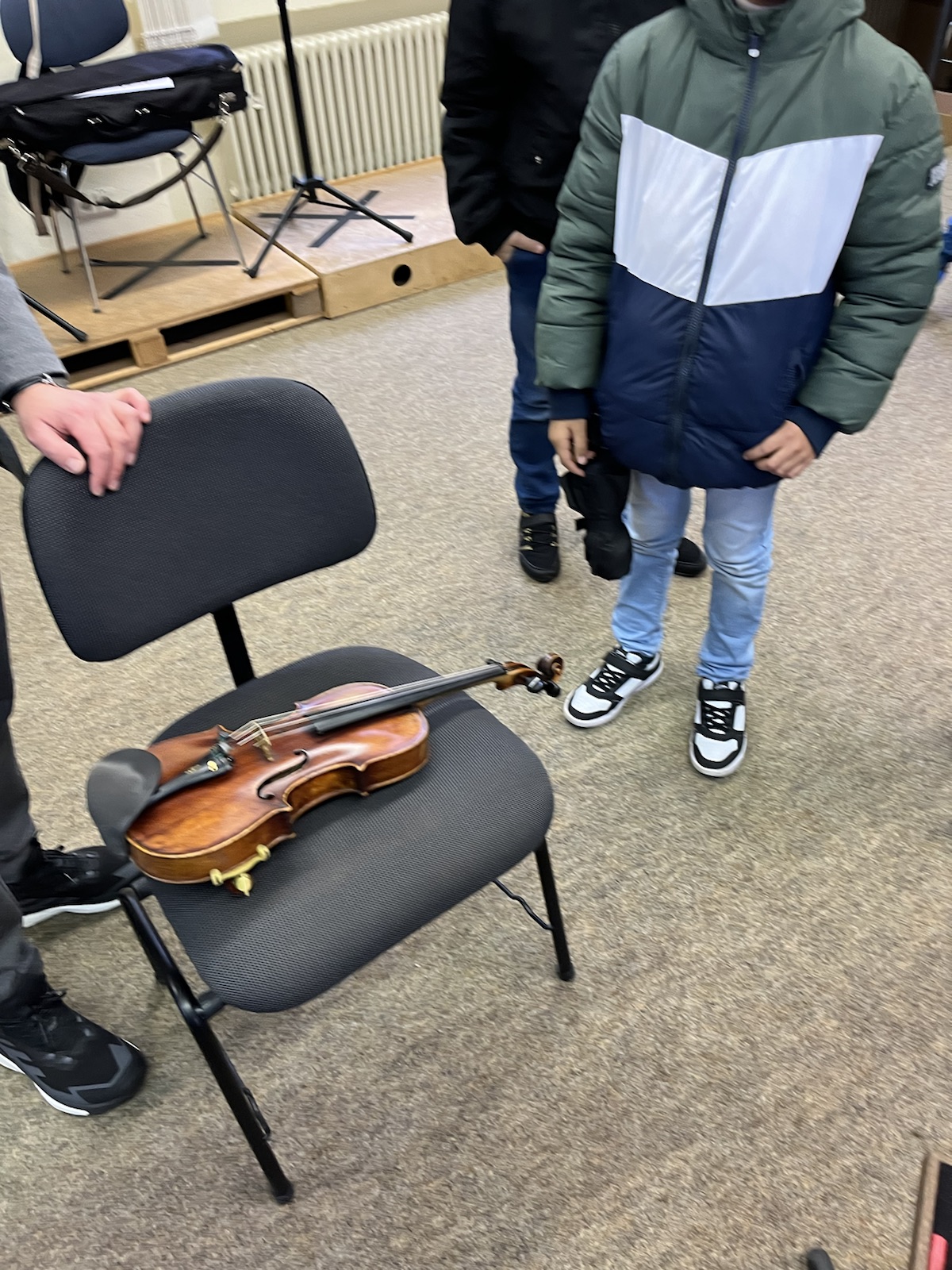 Man sieht eine Geige auf einem Stuhl liegen