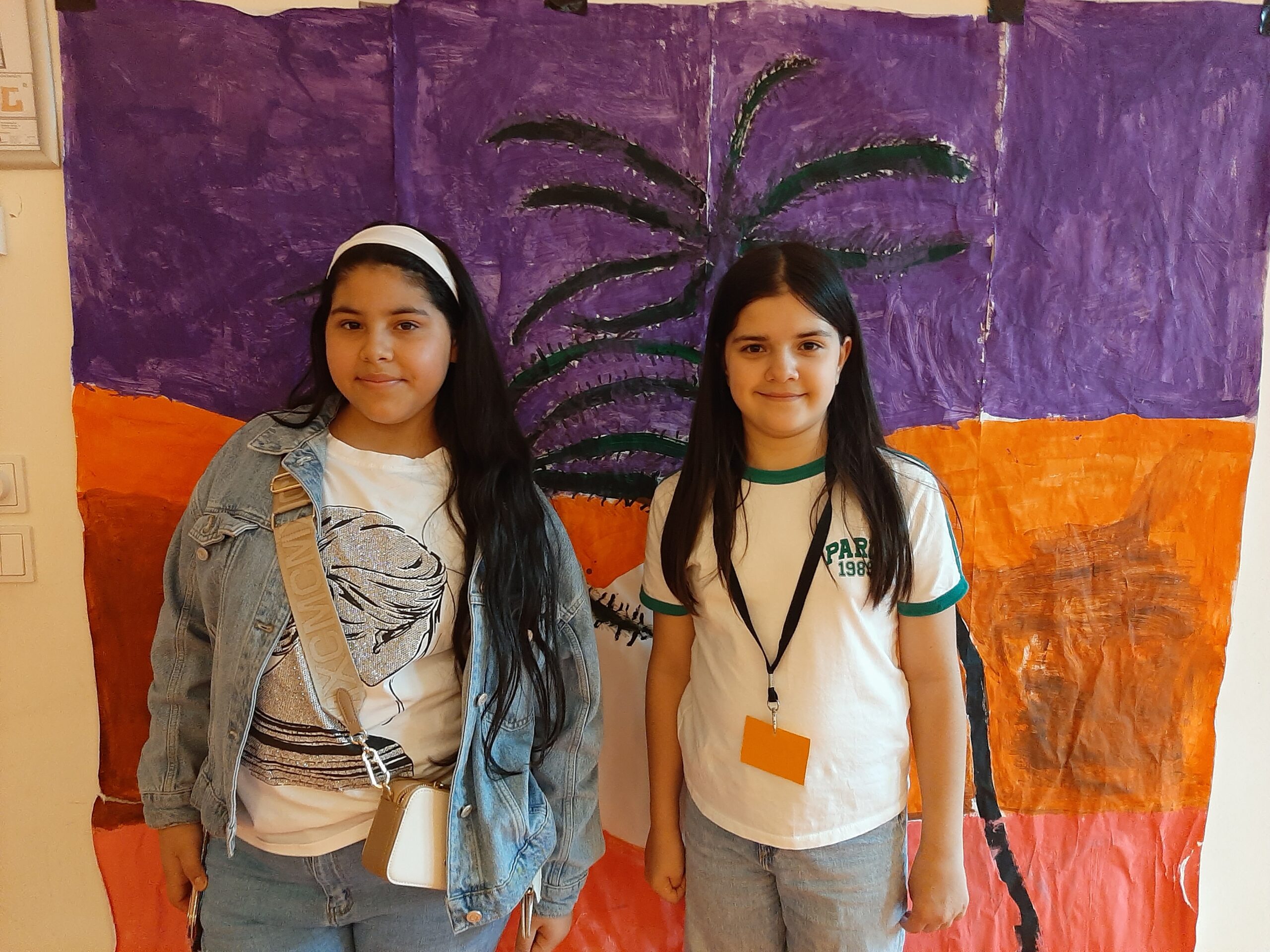 Zwei Schülerinnen vor gemaltem Hintergrund