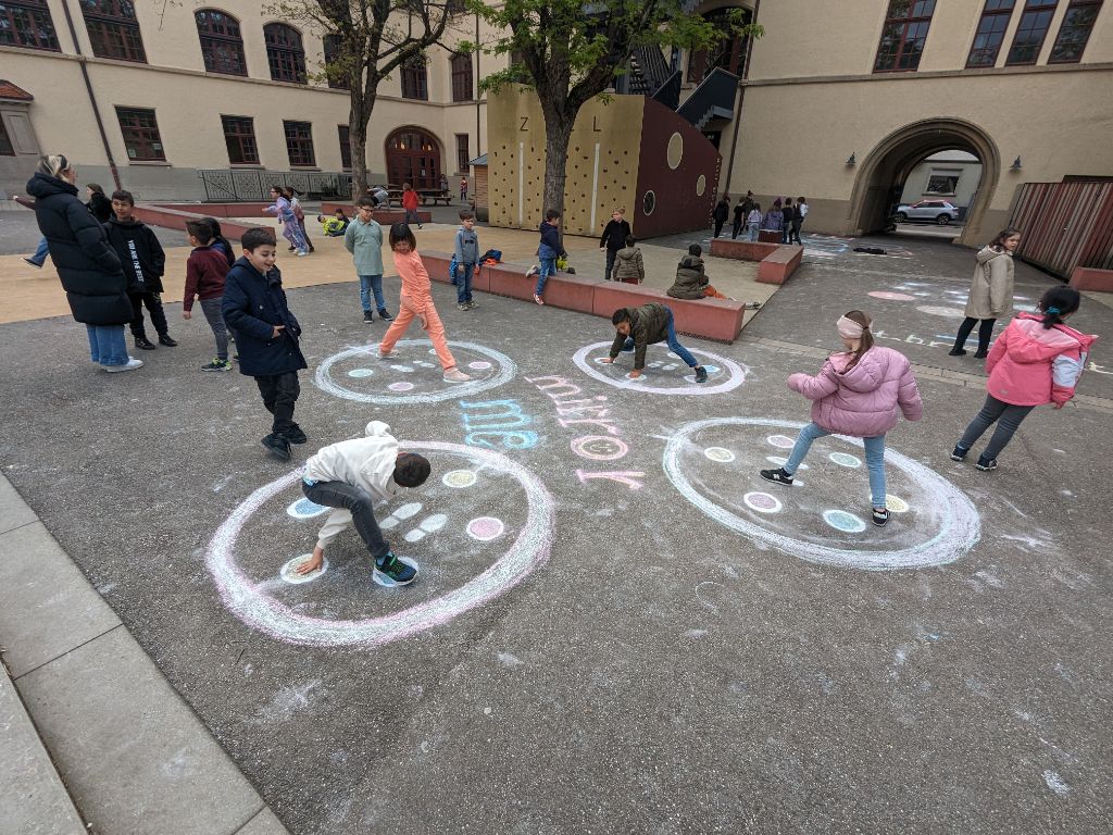 Schüler auf dem Schulhof bei aufgesprühten Bewegungsspielen